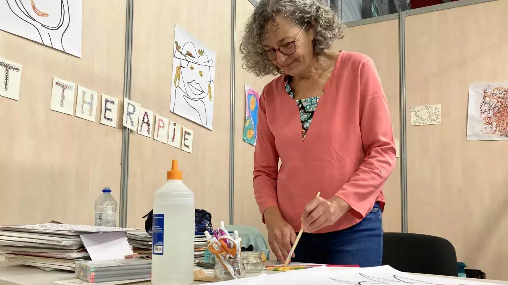 Christine Thévenet peignant à son stand d'art-thérapie au salon Respire la Vie à Poitiers