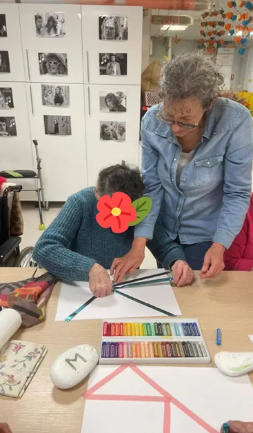 Christine Thévenet accompagnant une participante dans une création aux pastels lors d'une rencontre CréaLien